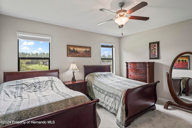 bedroom with ceiling fan and light tile patterned flooring