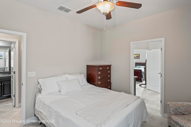 tiled bedroom featuring ceiling fan and connected bathroom