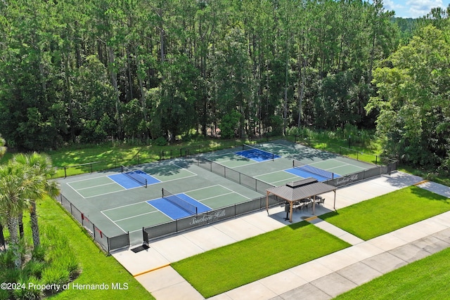 view of sport court featuring a lawn