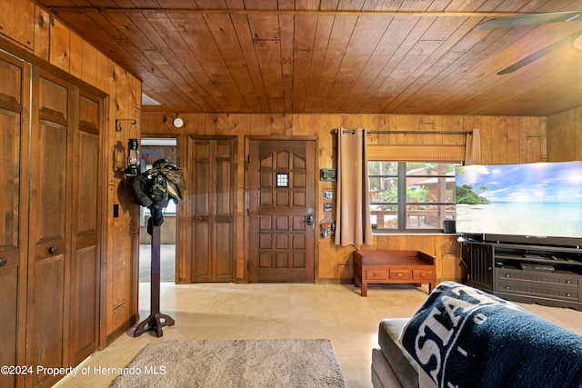 interior space with wood walls, ceiling fan, and wood ceiling