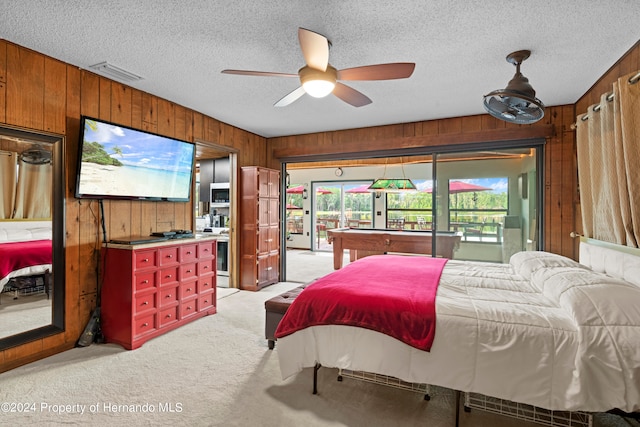 bedroom with light colored carpet, multiple windows, and a textured ceiling