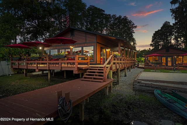 back house at dusk featuring a deck