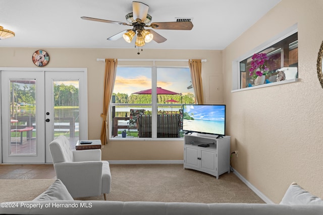 carpeted living room featuring french doors and ceiling fan