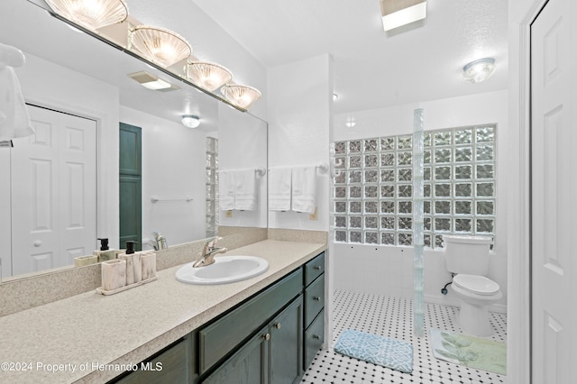 bathroom featuring toilet, vanity, tile patterned flooring, and walk in shower