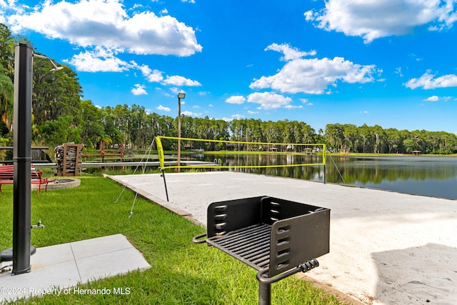 view of community with a yard, a water view, and volleyball court