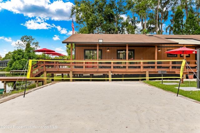 view of front of property featuring volleyball court and a wooden deck