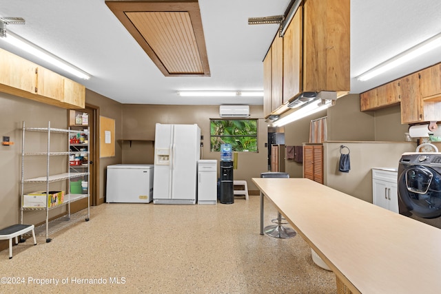 interior space with white refrigerator, an AC wall unit, white fridge with ice dispenser, and washer / clothes dryer