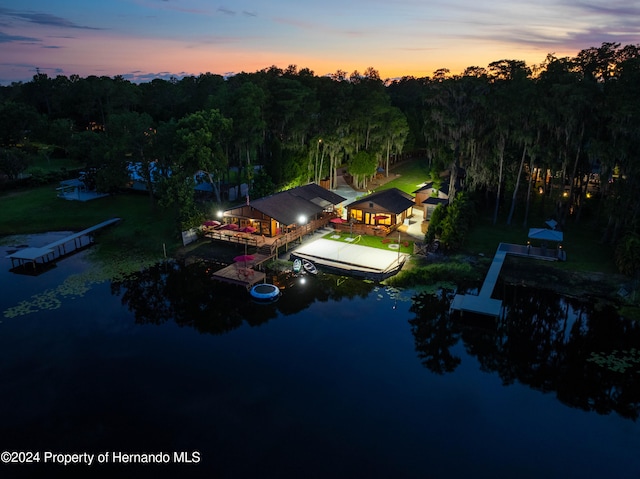 aerial view at dusk featuring a water view