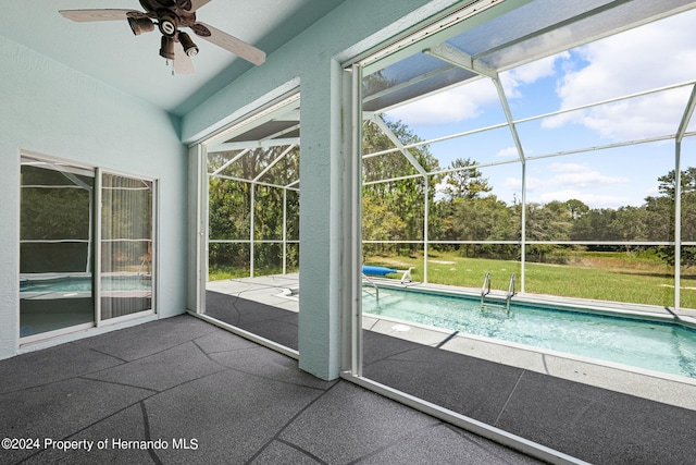 unfurnished sunroom featuring a swimming pool and ceiling fan