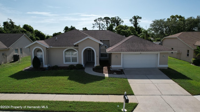 ranch-style home with central AC unit, a garage, and a front yard