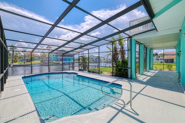 view of pool with a water view, glass enclosure, and a patio