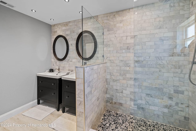 bathroom with vanity and a tile shower