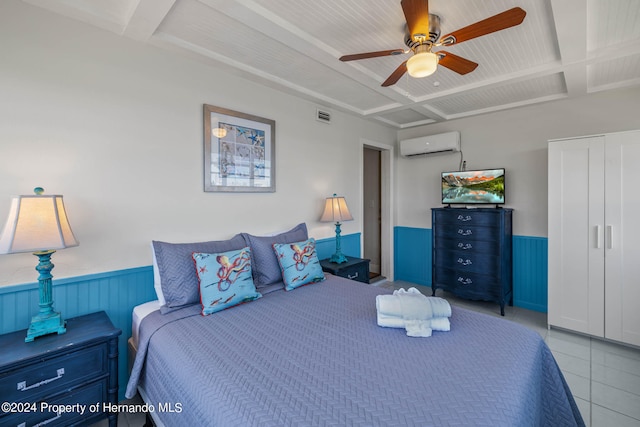 bedroom with a wall mounted AC, wood walls, light tile patterned floors, coffered ceiling, and ceiling fan