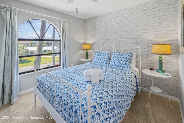 carpeted bedroom featuring a textured ceiling and ceiling fan