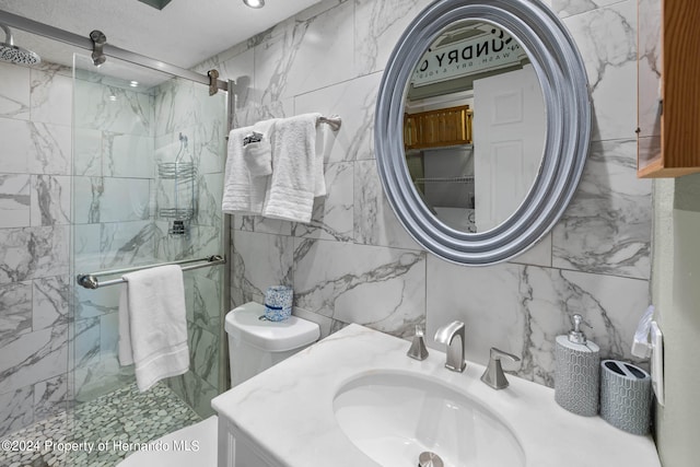 bathroom featuring toilet, vanity, an enclosed shower, and tile walls