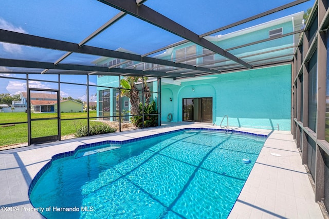 view of swimming pool with a lawn, glass enclosure, and a patio