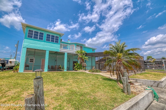 view of front facade with a front yard, glass enclosure, and a balcony