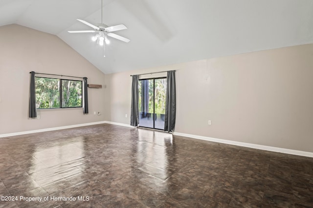 empty room with a wealth of natural light, ceiling fan, and vaulted ceiling