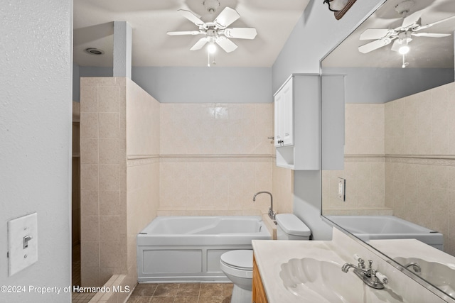 bathroom featuring tile patterned flooring, vanity, a bathing tub, toilet, and tile walls