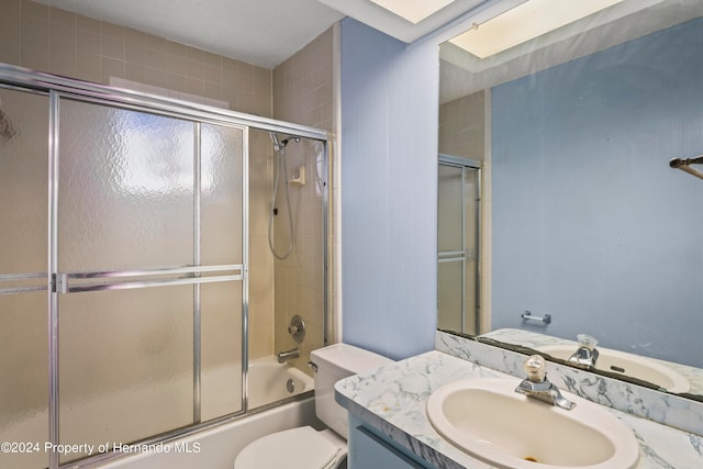 full bathroom with shower / bath combination with glass door, vanity, and toilet