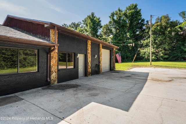 view of side of property with a lawn and a garage