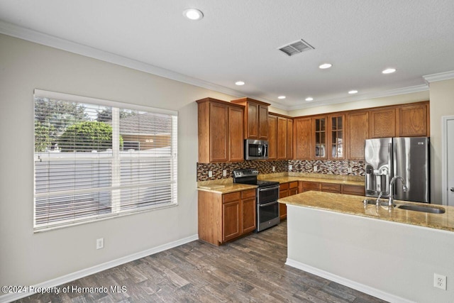 kitchen featuring light stone countertops, sink, dark wood-type flooring, crown molding, and appliances with stainless steel finishes