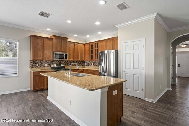 kitchen featuring dark hardwood / wood-style flooring, sink, stainless steel appliances, and a kitchen island with sink