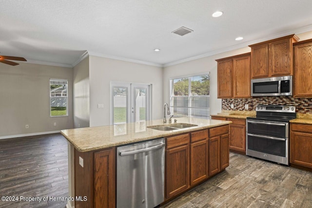 kitchen featuring dark hardwood / wood-style flooring, sink, an island with sink, and appliances with stainless steel finishes