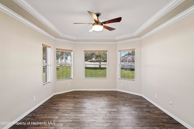 spare room featuring a healthy amount of sunlight, dark hardwood / wood-style floors, and ornamental molding