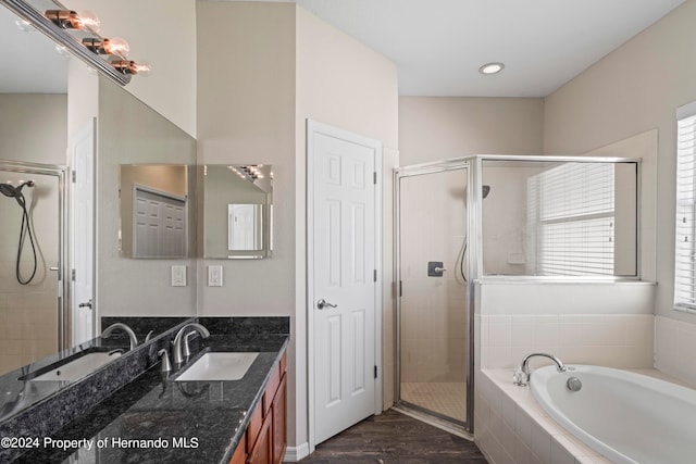 bathroom featuring wood-type flooring, vanity, and separate shower and tub