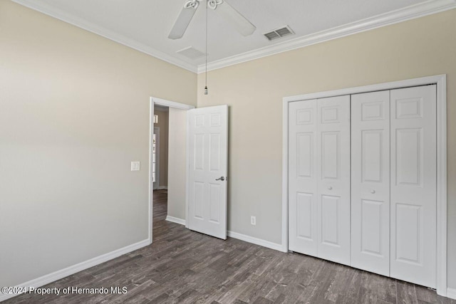 unfurnished bedroom featuring ceiling fan, dark hardwood / wood-style floors, ornamental molding, and a closet