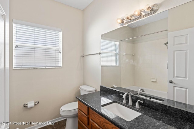 full bathroom featuring vanity, hardwood / wood-style flooring, toilet, and tiled shower / bath