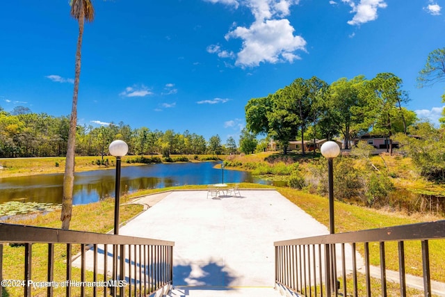 view of patio with a water view and basketball court