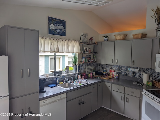 kitchen with white appliances, sink, backsplash, and lofted ceiling