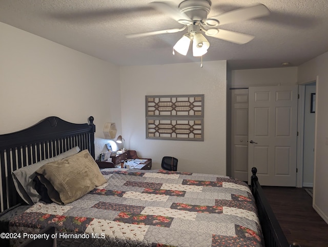 bedroom featuring a closet, a textured ceiling, ceiling fan, and dark hardwood / wood-style floors