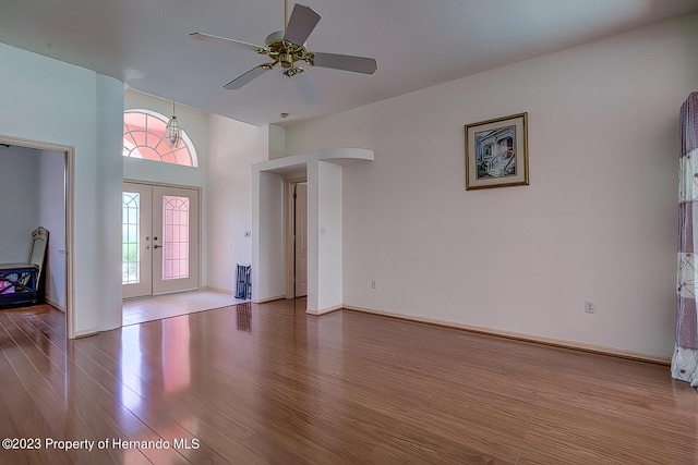 foyer entrance featuring light hardwood / wood-style floors, ceiling fan, a high ceiling, and french doors