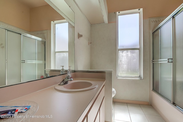 full bathroom featuring enclosed tub / shower combo, vanity, tile patterned floors, and toilet