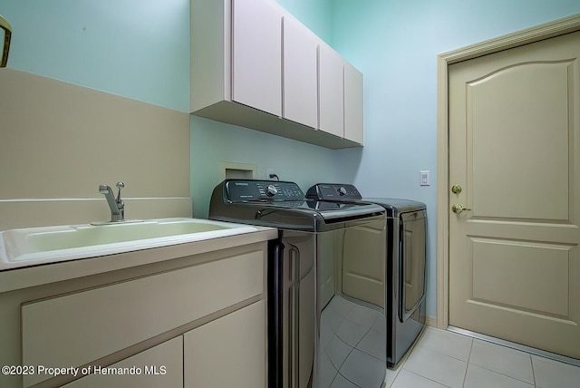 washroom with cabinets, sink, light tile patterned floors, and separate washer and dryer