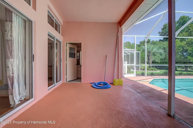 view of swimming pool with glass enclosure and a patio area