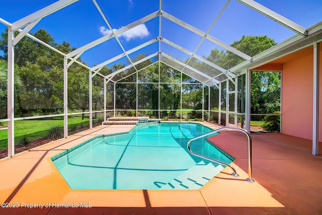 view of swimming pool with a lawn, glass enclosure, and a patio