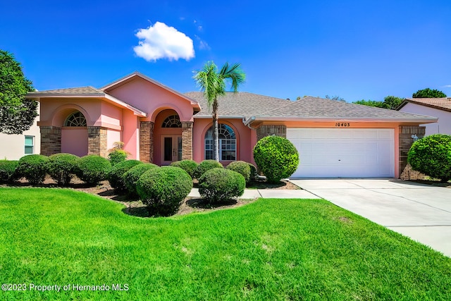 ranch-style home with a front yard and a garage