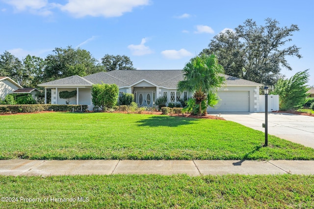 ranch-style house featuring a garage and a front lawn