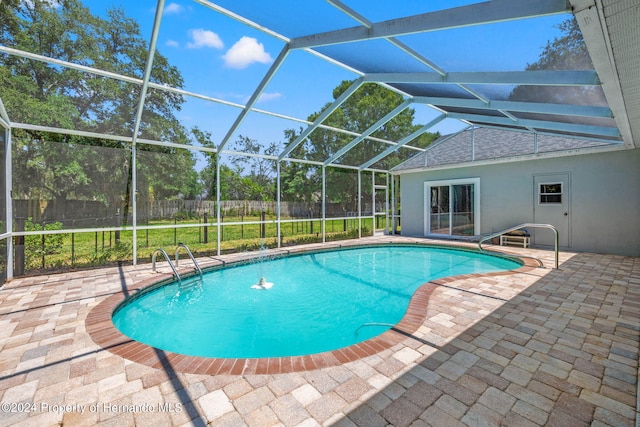 view of swimming pool featuring a lanai and a patio