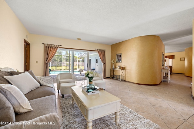 tiled living room featuring a textured ceiling