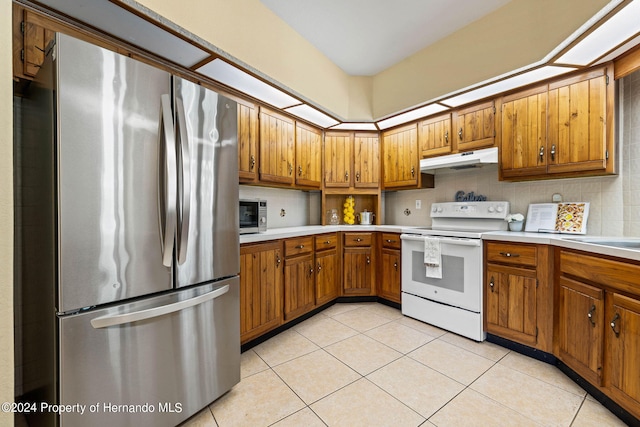 kitchen featuring appliances with stainless steel finishes, light tile patterned floors, and backsplash