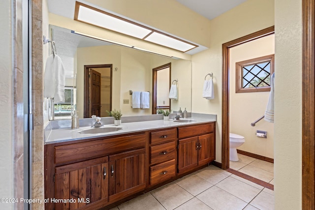 bathroom with tile patterned flooring, vanity, and toilet