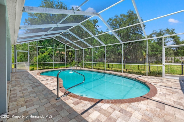 view of pool featuring glass enclosure and a patio