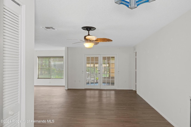 spare room with ceiling fan, french doors, dark wood-type flooring, and a textured ceiling