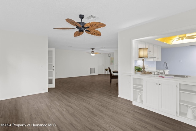 kitchen featuring white cabinetry, ceiling fan, dark wood-type flooring, a textured ceiling, and sink