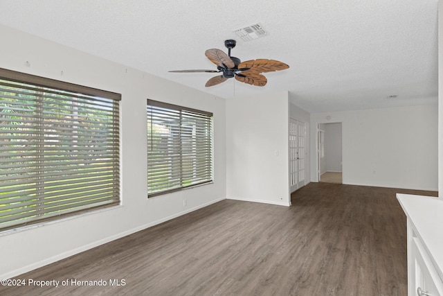 unfurnished room featuring ceiling fan, dark hardwood / wood-style floors, and a textured ceiling